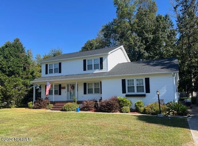 view of front of home featuring covered porch and a front lawn