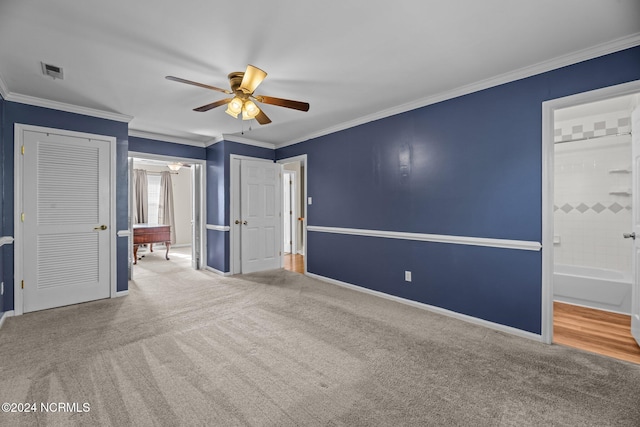 unfurnished bedroom with crown molding, ensuite bath, carpet flooring, and ceiling fan