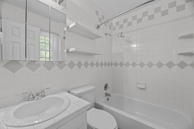 full bathroom with tiled shower / bath, decorative backsplash, tile walls, toilet, and vanity