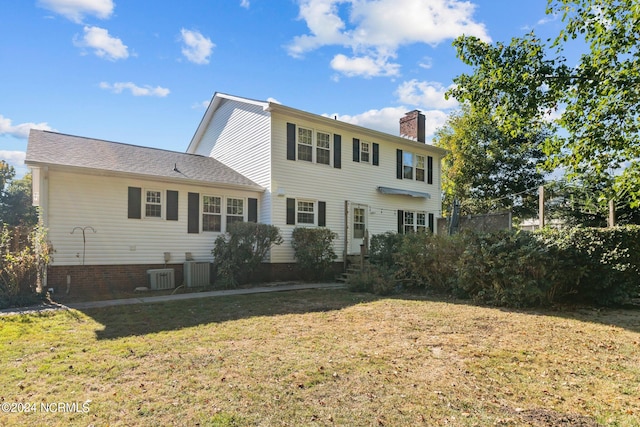 back of house with central air condition unit and a lawn