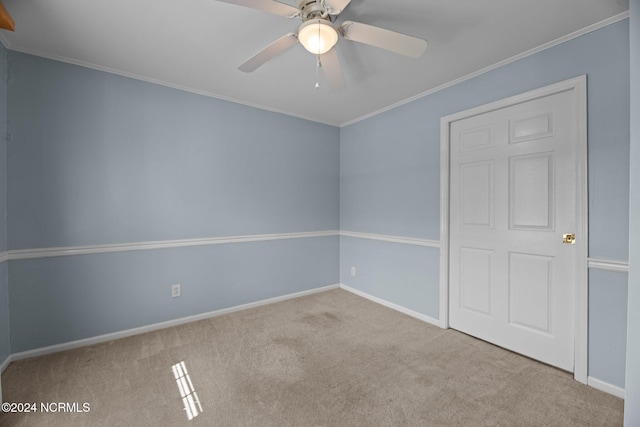 empty room featuring ceiling fan, ornamental molding, and light colored carpet