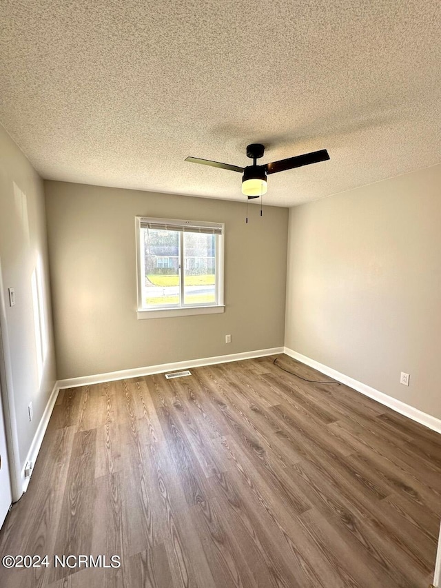 spare room featuring ceiling fan, hardwood / wood-style flooring, and a textured ceiling