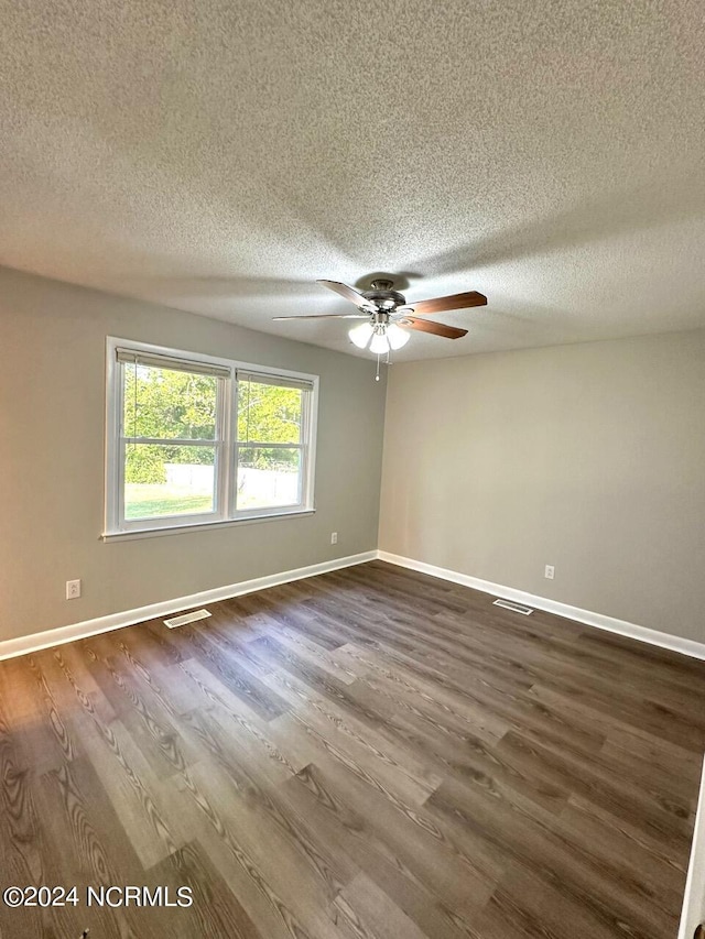 empty room featuring ceiling fan, a textured ceiling, and dark hardwood / wood-style floors