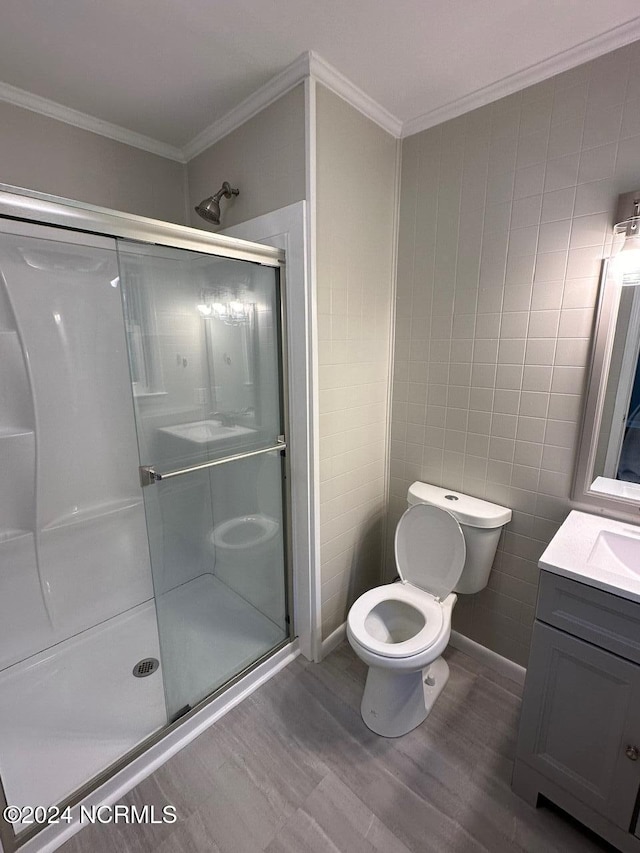 bathroom featuring hardwood / wood-style floors, toilet, tile walls, walk in shower, and vanity