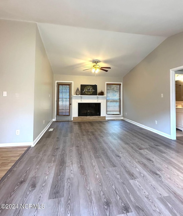 unfurnished living room with lofted ceiling, hardwood / wood-style flooring, and ceiling fan