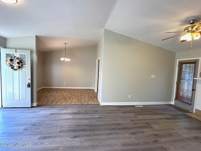 foyer entrance with lofted ceiling, dark hardwood / wood-style floors, and ceiling fan with notable chandelier