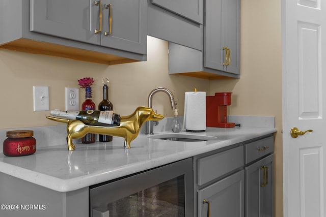 kitchen featuring gray cabinets, sink, and beverage cooler