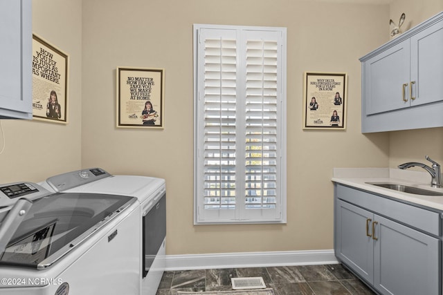 laundry room with cabinets, sink, and washer and dryer