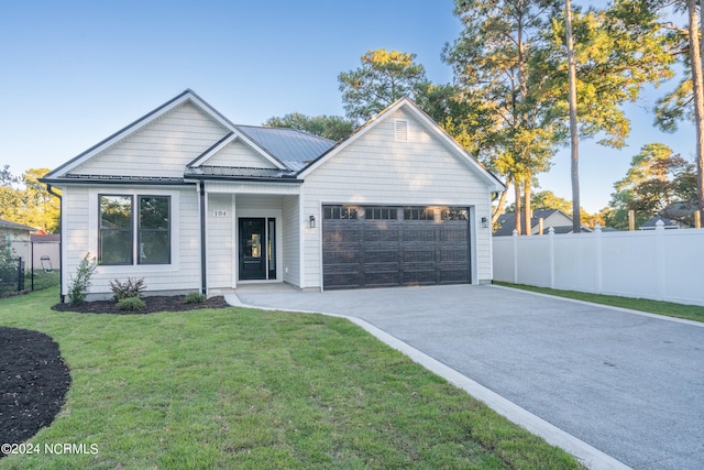 modern farmhouse with a front yard and a garage