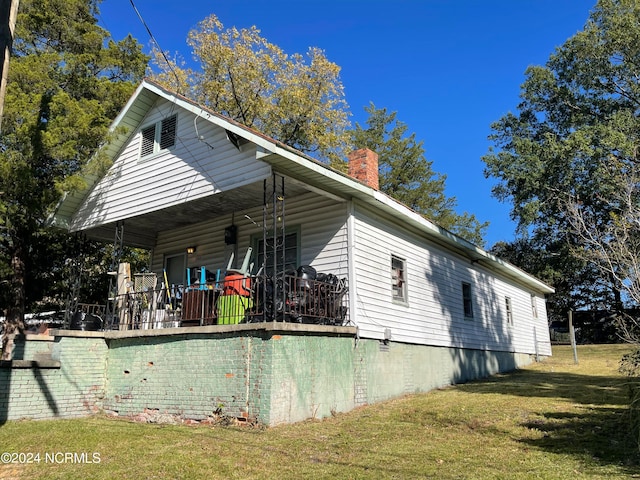 view of side of property with a wooden deck and a lawn