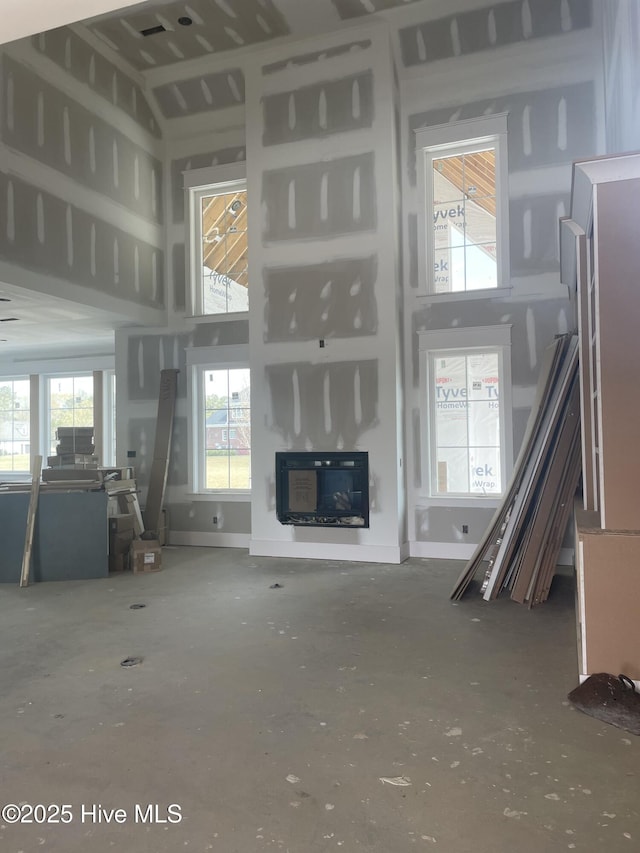 3413 Autumn Breeze Ct, Grimesland, NC 27837 - unfurnished living room with a high ceiling and a glass covered fireplace