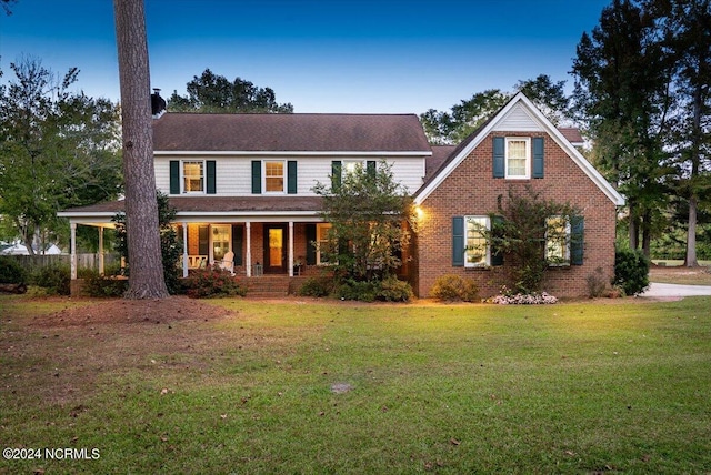 view of front facade featuring covered porch and a front yard