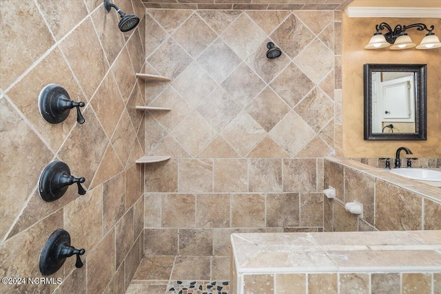 bathroom with crown molding, sink, and tiled shower