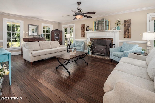 living room featuring dark hardwood / wood-style flooring, a brick fireplace, ceiling fan, and crown molding