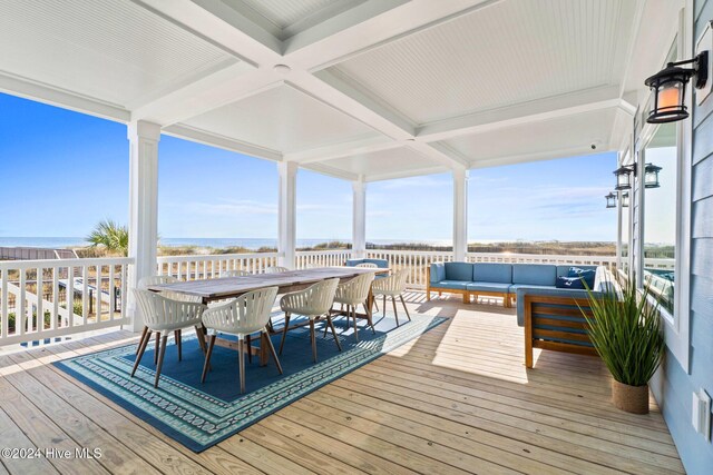 wooden terrace with an outdoor living space and a water view