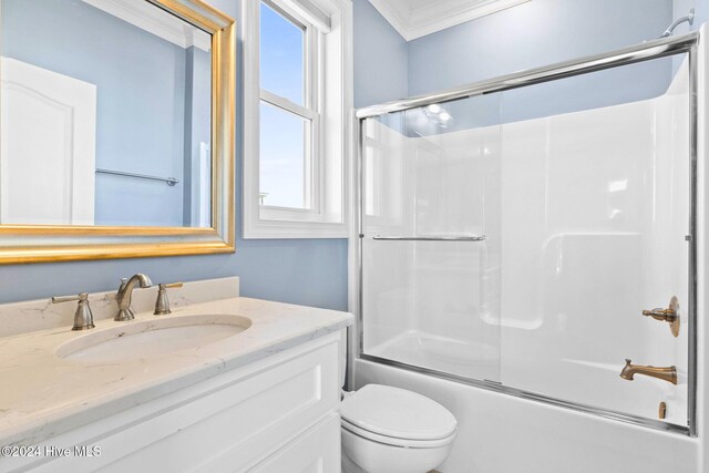 full bathroom with crown molding, bath / shower combo with glass door, vanity, and toilet