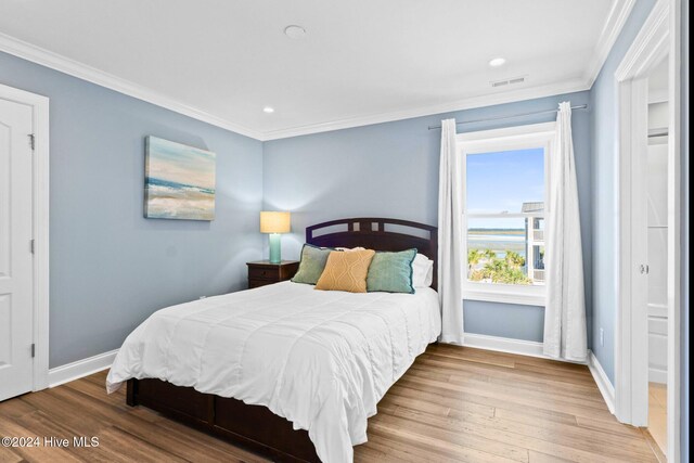 bedroom featuring hardwood / wood-style floors and crown molding