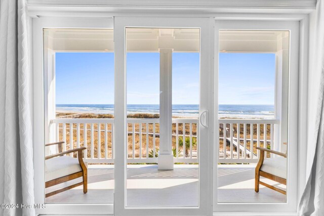 doorway to outside with a wealth of natural light, a view of the beach, and a water view