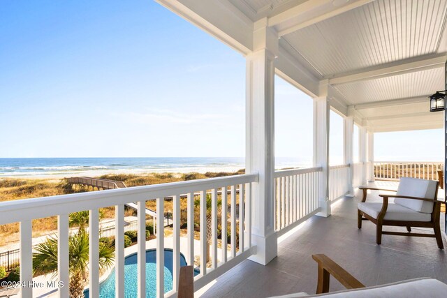 balcony featuring a beach view and a water view