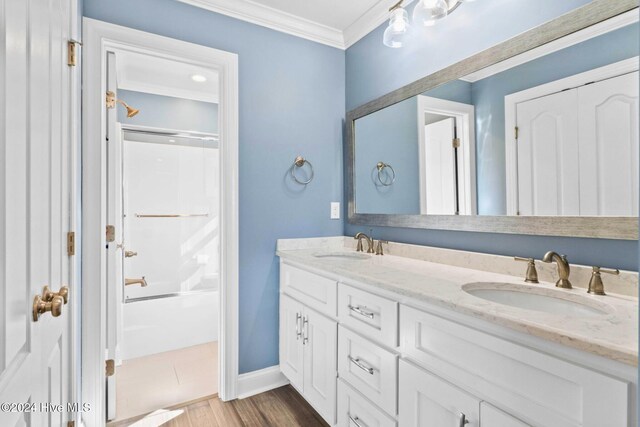 bathroom with ornamental molding, enclosed tub / shower combo, vanity, and wood-type flooring