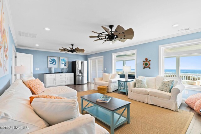 living room featuring hardwood / wood-style floors, ceiling fan, a water view, and ornamental molding