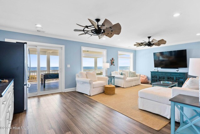 living room with hardwood / wood-style floors, ceiling fan, and crown molding