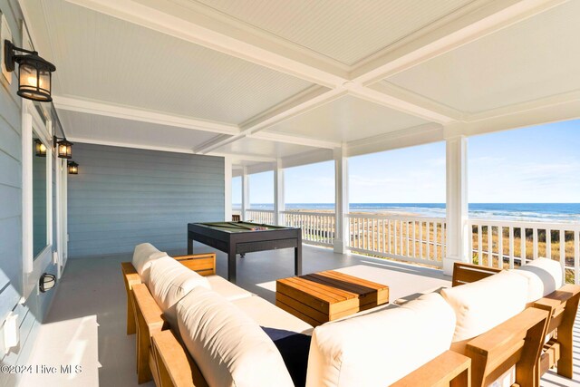 sunroom / solarium with a water view, a view of the beach, billiards, and beam ceiling