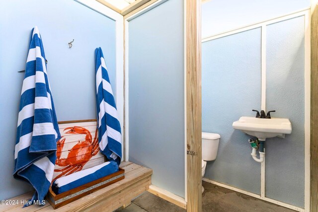 bathroom with toilet and concrete floors