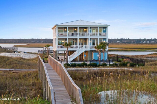 rear view of property with a water view and a balcony