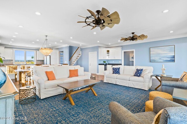 living room featuring wood-type flooring, crown molding, and ceiling fan with notable chandelier