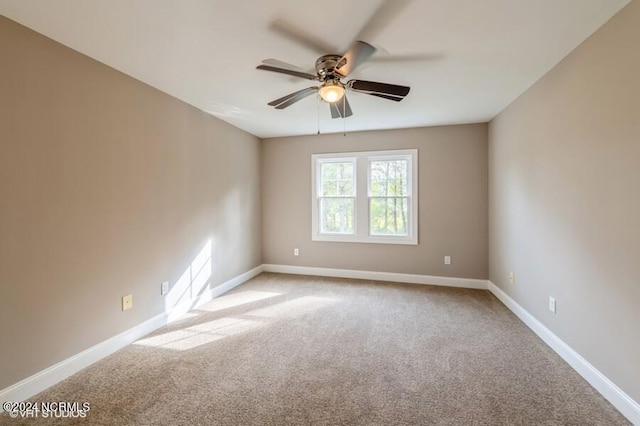 empty room featuring light colored carpet and ceiling fan