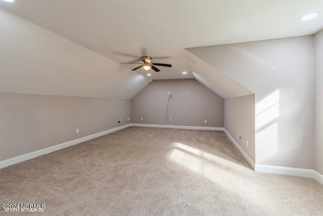 additional living space featuring lofted ceiling, light carpet, and ceiling fan