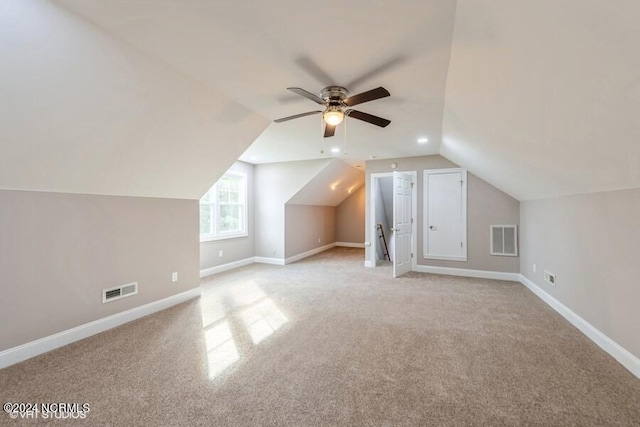 bonus room with vaulted ceiling, light colored carpet, and ceiling fan