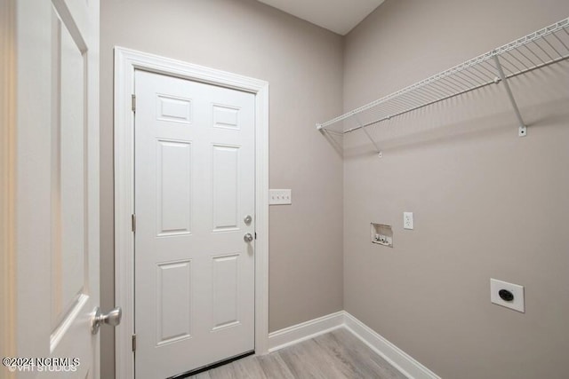 washroom with hookup for an electric dryer and light hardwood / wood-style flooring