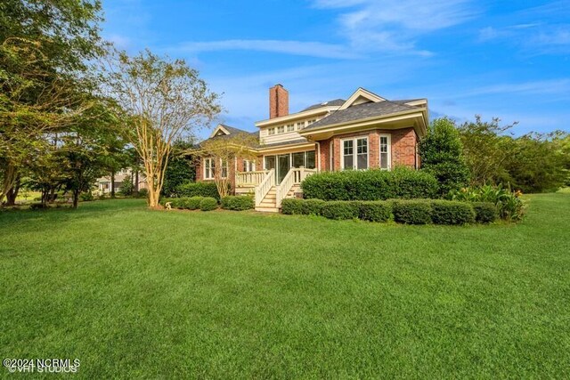 rear view of property with a lawn