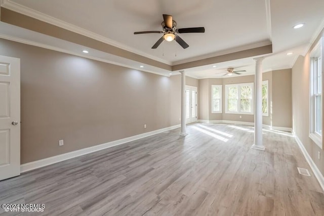 spare room with ornate columns, ornamental molding, light hardwood / wood-style floors, and ceiling fan