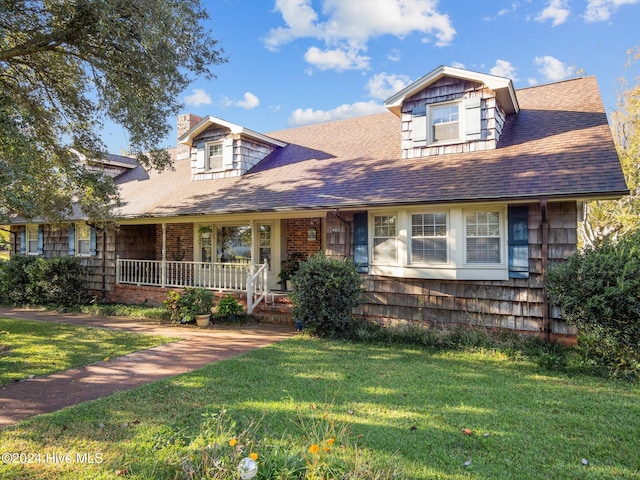 403 W Spring St, Swansboro, NC 28584 - view of front of home featuring covered porch, a front lawn, and roof with shingles