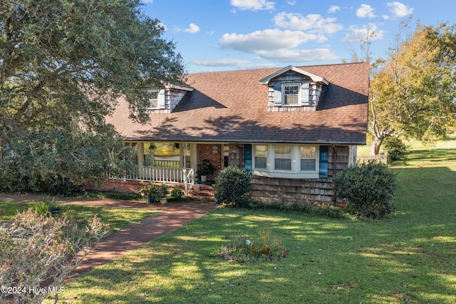 cape cod-style house featuring a front lawn and covered porch