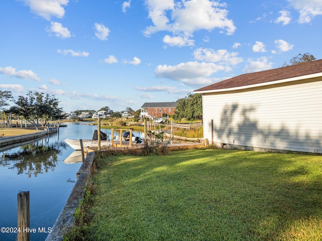 dock area with a water view and a lawn