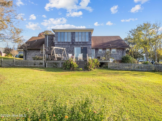 back of house with a deck and a yard