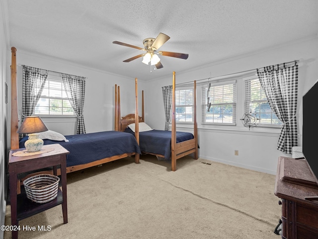 carpeted bedroom featuring ornamental molding, a textured ceiling, and ceiling fan