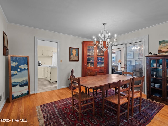 dining room featuring light hardwood / wood-style floors, an inviting chandelier, and ornamental molding