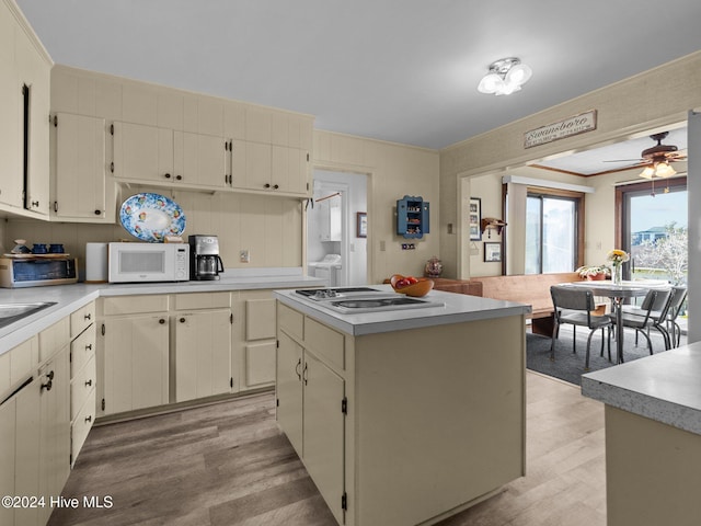 kitchen with ceiling fan, white appliances, light hardwood / wood-style flooring, a center island, and cream cabinetry