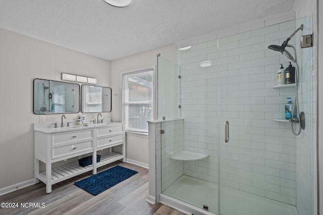 bathroom featuring vanity, a textured ceiling, wood-type flooring, and an enclosed shower