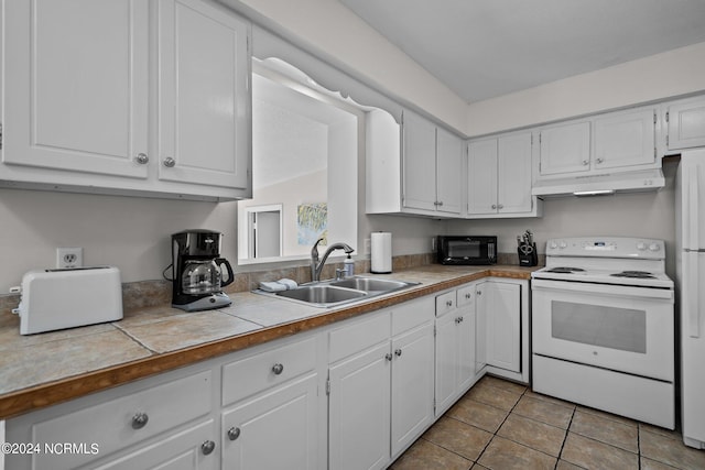 kitchen featuring white cabinets, tile countertops, white electric range oven, light tile patterned flooring, and sink