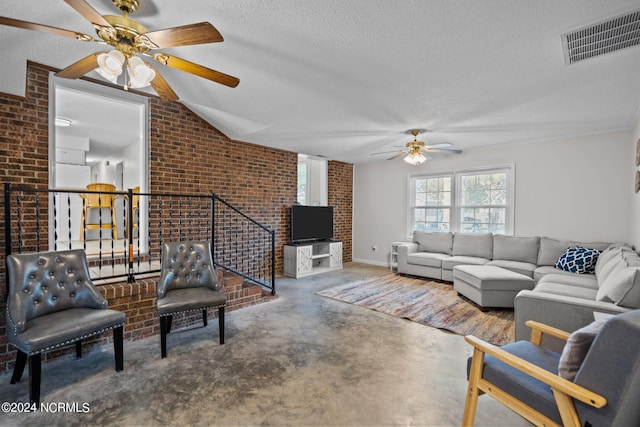 living room with lofted ceiling, ceiling fan, concrete floors, a textured ceiling, and brick wall