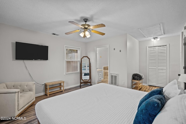 bedroom with a closet, wood-type flooring, ensuite bath, a textured ceiling, and ceiling fan