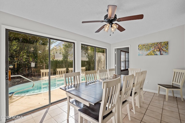 tiled dining room with ceiling fan and a textured ceiling