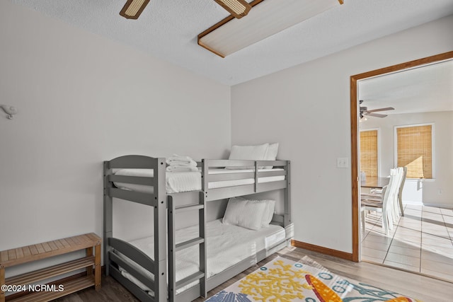 bedroom featuring a textured ceiling, wood-type flooring, and ceiling fan