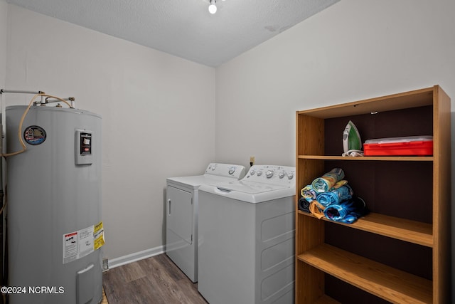 laundry room featuring water heater, a textured ceiling, washing machine and dryer, and dark hardwood / wood-style floors